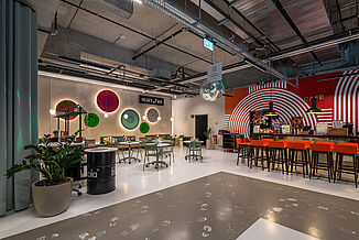 A modern community and dining space at Kalle Neukölln in Berlin – sustainable regeneration featuring flexible workspaces and communal areas.