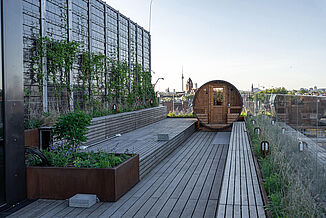 Kalle’s roof terrace, featuring a sauna barrel, cosy seating and a modern ambience, is perfect for relaxing outdoor wellness moments.