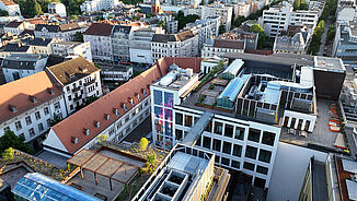 An aerial view of a revitalised urban neighbourhood in Berlin, featuring green roof terraces and sustainable roof architecture.